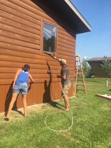 Resort ownership requires ongonig maintenance. Owners Lisa and Jason Goulet update the exteriors of one of the cabins.